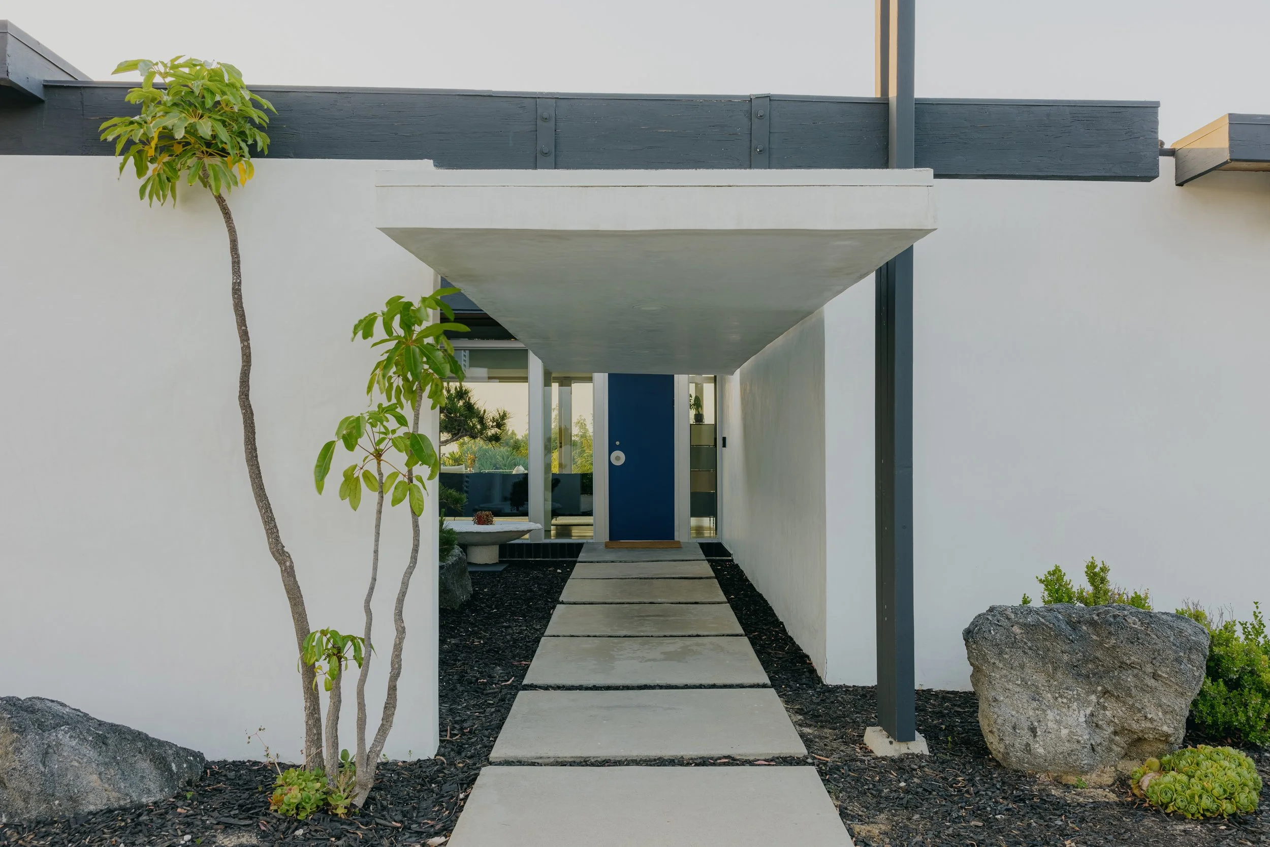 Entrance beneath a floating white canopy